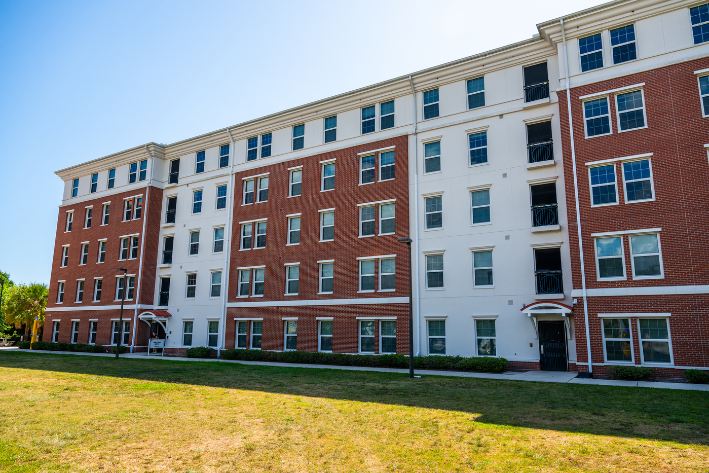 L3Harris Village Building C, a large five story apartment building with brick and stucco facade